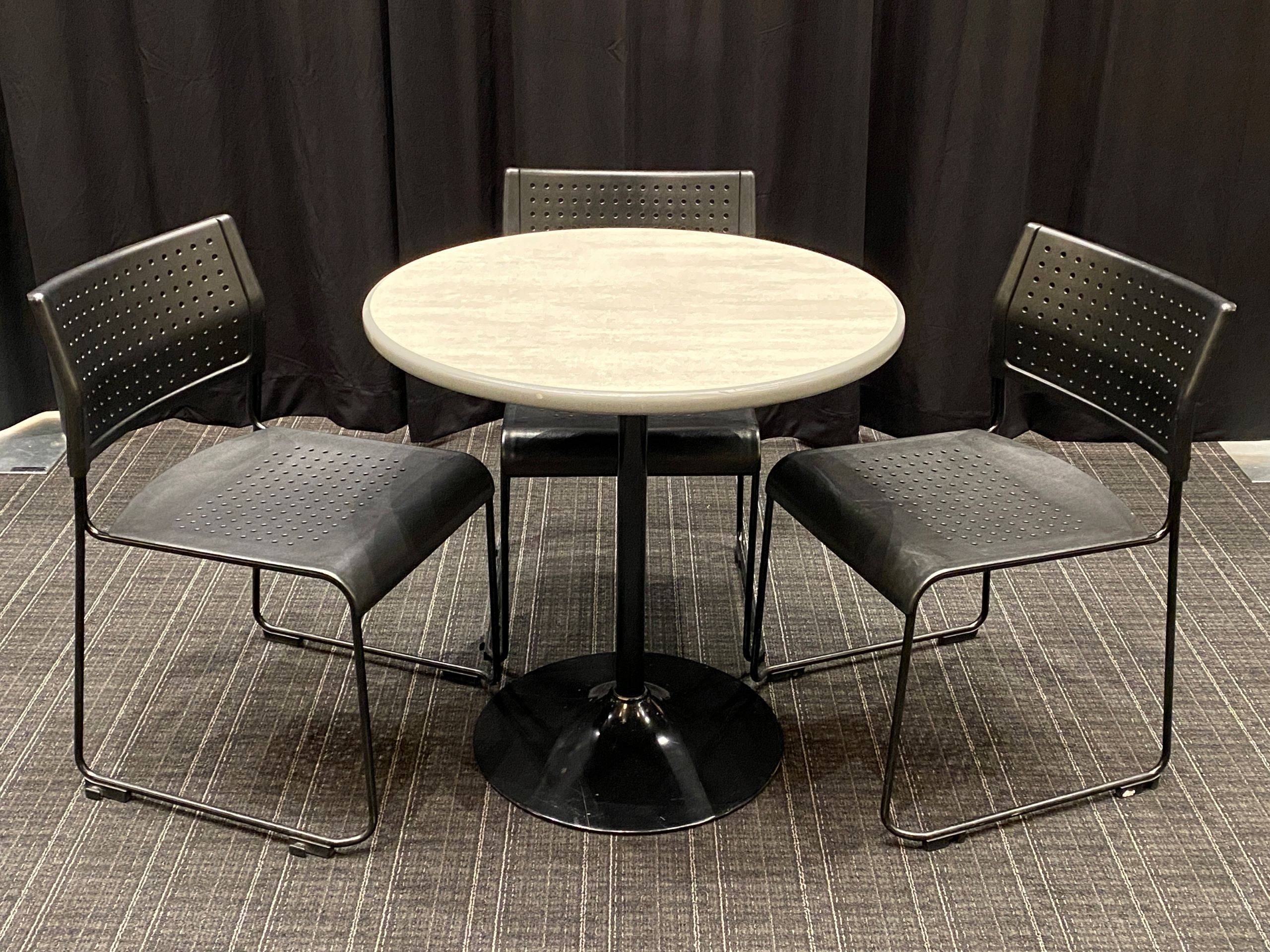 A bistro table at seated-height with 3 chairs.